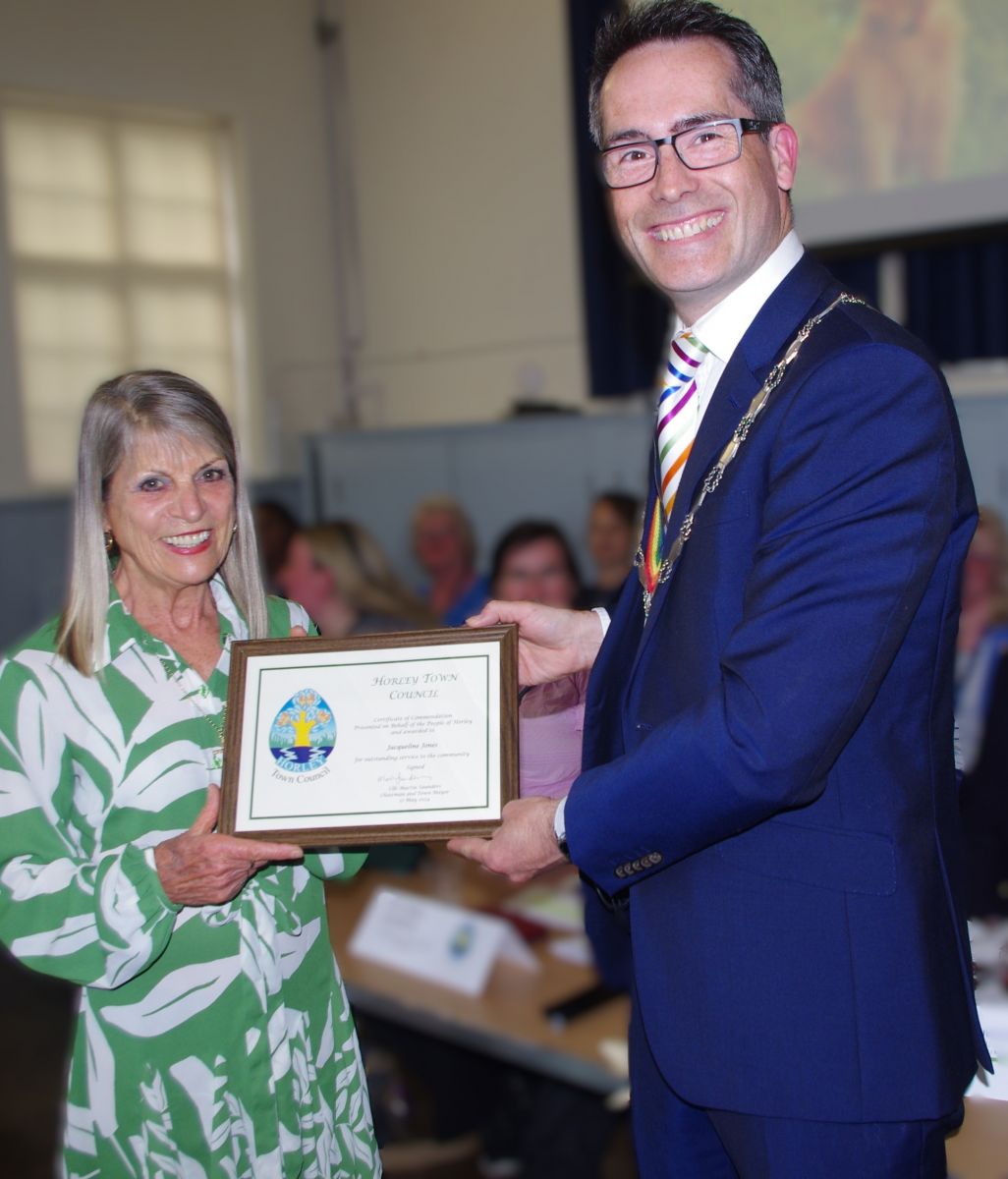 Photograph of Jacqueline receiving the award from Mayor Cllr Saunders