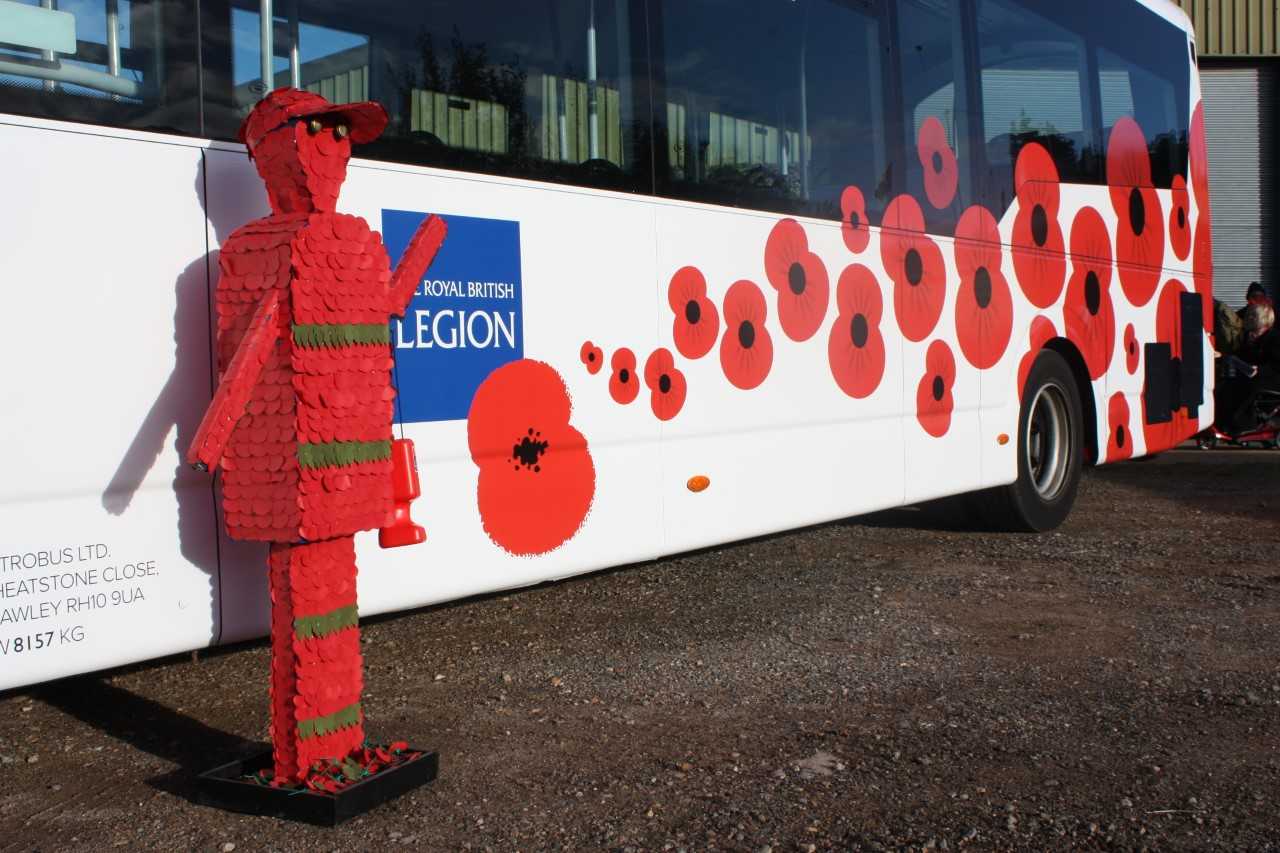 A photo of a bus decorated with the Royal British Legion logo and images of poppys